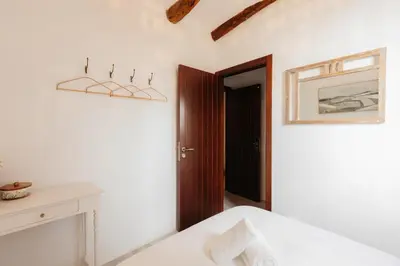 a white room with a bed and a door at Brisas Chulilla Boutique Apartment in Chulilla