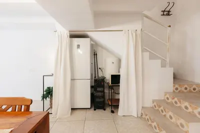 a living room with a staircase and white curtains at Brisas Chulilla Boutique Apartment in Chulilla