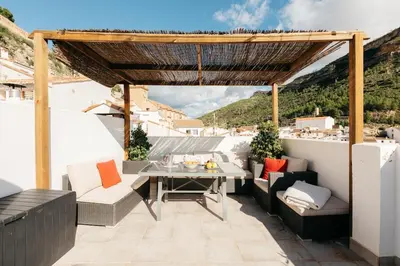 a patio with a table and chairs on a roof at Brisas Chulilla Mirador House in Chulilla