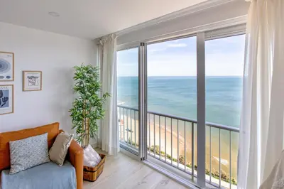 a living room with a dresser and a large window at Inolvidables vistas en perfecto apto frente al mar in Faro de Cullera