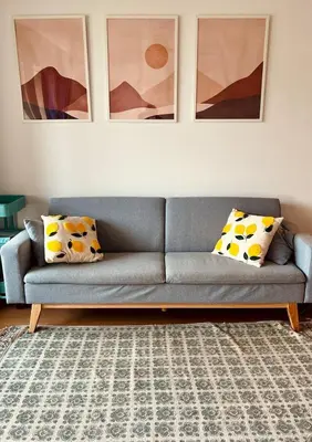 a blue couch in a living room with paintings at Beachfront Family Apt in Valencia