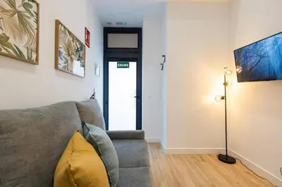 a living room with a gray couch and a lamp at Suite de diseño en Roig Arena in Valencia