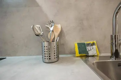 a metal container with utensils on a counter next to a sink at Suite de diseño en Roig Arena in Valencia