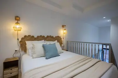 a bedroom with a large white bed with two lights at Suite de diseño en Roig Arena in Valencia