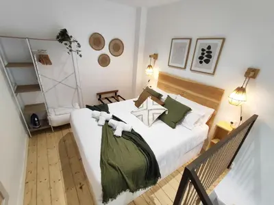 a bedroom with a white bed with green pillows at Loft acogedor junto al Roig Arena in Valencia