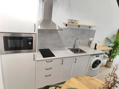 a white kitchen with a sink and a dishwasher at Loft acogedor junto al Roig Arena in Valencia