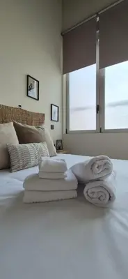 a bedroom with towels on a bed with a window at Impresionante Apartamento Industrial wifi gratis hasta 4 os encantará in Valencia