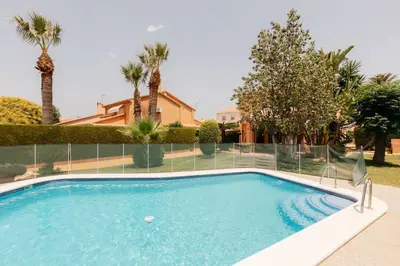 a swimming pool in a yard with palm trees at Charming brand-new loft with garden and pool in Pla del Pou