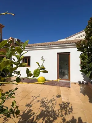 a white house with a courtyard with a door at Charming brand-new loft with garden and pool in Pla del Pou