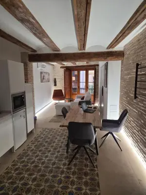 a kitchen and living room with a wooden table and chairs at Valencia Catedral Apt in Valencia