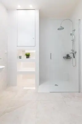 a white bathroom with a shower and a sink at Portobello Road Suites in Valencia