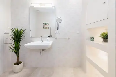 a white bathroom with a sink and a mirror at Portobello Road Suites in Valencia
