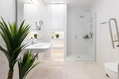 a white bathroom with a sink and a shower at Portobello Road Suites in Valencia