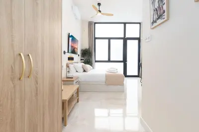 a bedroom with a bed and a window at Portobello Road Suites in Valencia