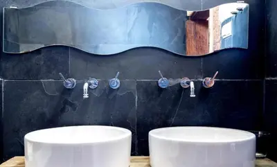 a bathroom with two white sinks and a black wall at Gran Ático Premium del Siglo XVI con Tres Terrazas Privadas Hasta 7 Huéspedes en Ciutat Vella in Valencia
