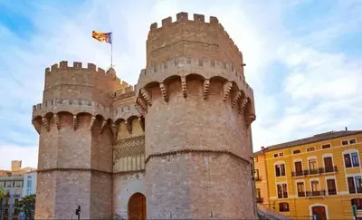 a castle with a flag on top of it at Gran Ático Premium del Siglo XVI con Tres Terrazas Privadas Hasta 7 Huéspedes en Ciutat Vella in Valencia