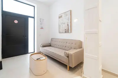 a living room with a couch in front of a door at VLC Host - Cubells 8 in Valencia