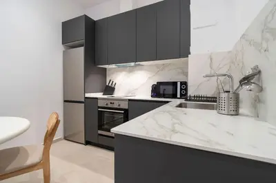 a kitchen with black cabinets and a white counter top at VLC Host - Cubells 8 in Valencia