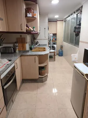a kitchen with wooden cabinets and a tile floor at Habitación doble 45eur in Valencia