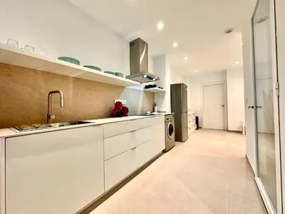 a white kitchen with a sink and a dishwasher at Casa Rosario - Apartamento reformado en El Cabañal in Valencia