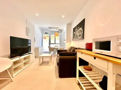 a living room with a couch and a tv at Casa Rosario - Apartamento reformado en El Cabañal in Valencia
