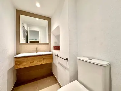 a bathroom with a toilet and a sink and a mirror at Casa Rosario - Apartamento reformado en El Cabañal in Valencia