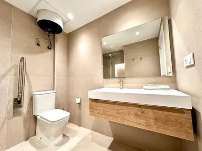a bathroom with a toilet and a sink and a mirror at Casa Rosario - Apartamento reformado en El Cabañal in Valencia