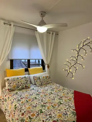 a bedroom with a bed with a ceiling fan at La Llum de Serra in Serra