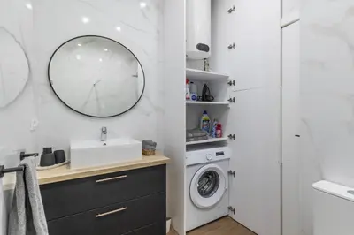 a bathroom with a sink and a washing machine at Prime Location, Bright & Cozy Apartment in Valencia