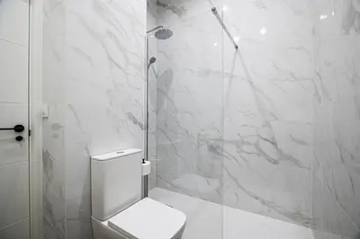 a bathroom with a toilet and a glass shower at Prime Location, Bright & Cozy Apartment in Valencia