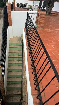 a set of stairs with a wrought iron railing at El Cortijo a cielo abierto entre montañas in Estivella