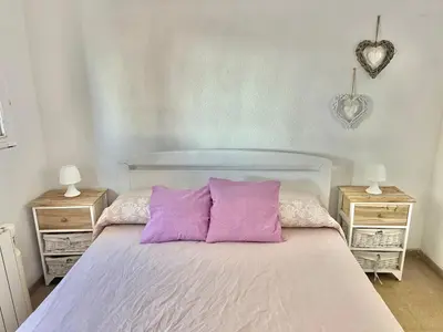 a bedroom with a bed with purple pillows and two night stands at El Cortijo a cielo abierto entre montañas in Estivella