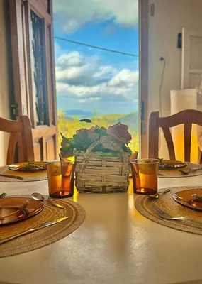 a table with two glasses and a basket of flowers on it at El Cortijo a cielo abierto entre montañas in Estivella