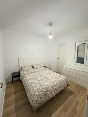 a white bedroom with a bed and a window at Apartamento bajo acogedor, moderno, cerca del Mar in Valencia
