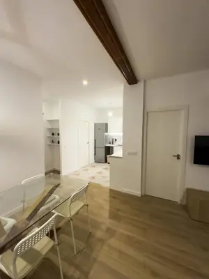 a living room with a glass table and chairs at Apartamento bajo acogedor, moderno, cerca del Mar in Valencia