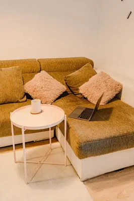 a couch with a table with a laptop on it at The Cabanal Beach House - 10 min to ocean, FastWifi, AC, Coffee in Valencia