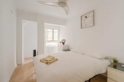 a white bedroom with a bed and a ceiling fan at The Cabanal Beach House - 10 min to ocean, FastWifi, AC, Coffee in Valencia