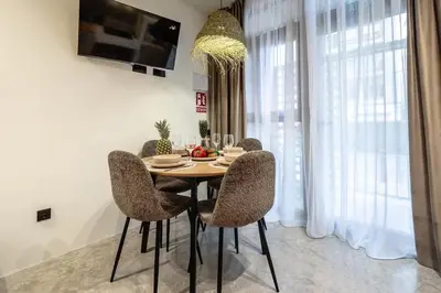 a dining room with a table with chairs and a television at Suite con terraza - Manolito 1 in Valencia