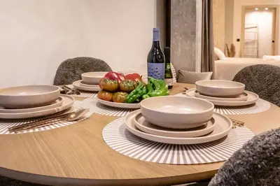 a wooden table with plates and bowls and vegetables on it at Suite Ciudad de las Ciencias y Puerto - Manolito 4 in Valencia
