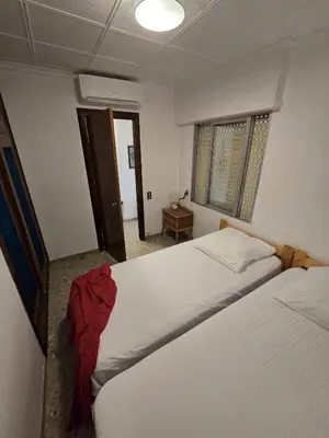 a bedroom with two beds and a room with a table at Simat Malina in Simat de Valldigna