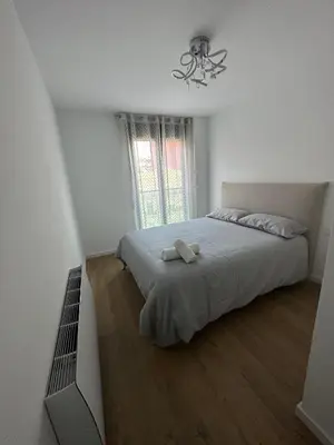 a bedroom with a bed and a chandelier at 60m2 Cozy Apartament in Valencia