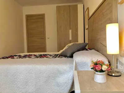 a bedroom with a bed and a table with a vase of flowers at Apartamento cerca de playa y Ciudad de Ciencias in Valencia