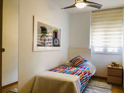 a bedroom with a bed and a bike on the wall at Apartamento cerca de playa y Ciudad de Ciencias in Valencia