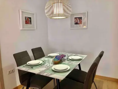 a dining room table with chairs and a chandelier at Apartamento cerca de playa y Ciudad de Ciencias in Valencia