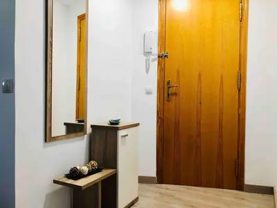 a bathroom with a wooden door and a mirror at Apartment near the beach and the City of Sciences in Valencia