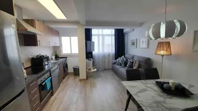 a kitchen and living room with a couch and a table at Apartment near the beach and the City of Sciences in Valencia