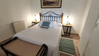 a bedroom with a large bed with two night stands at Casa Principal Finca Mas el Bravo in Caudiel