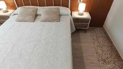a bed with two pillows and two night stands at Casa Principal Finca Mas el Bravo in Caudiel