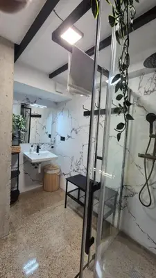 a bathroom with a sink and a glass door at Excepcional Amplio Apartamento Industrial Fallas hasta 6, wifi gratis cuna in Valencia