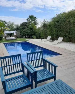 two blue benches sitting next to a swimming pool at Valencia luxury in Valencia